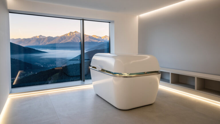 Модерен SPA център с флотационна капсула и гледка към планината.