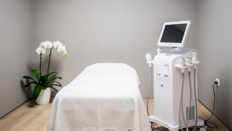 Модерен спа кабинет с апарат за процедурата hydrafacial до кушетката.