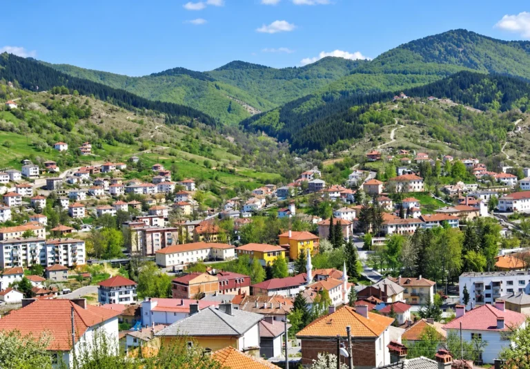 Панорамна гледка към планински град сред зелени хълмове