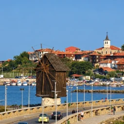Вятърната мелница на провлака към Стария Несебър с пристанището и червените покриви на заден план.
