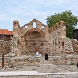 Каменните стени и арки на базиликата „Света София“ в Несебър с посетители сред останките.